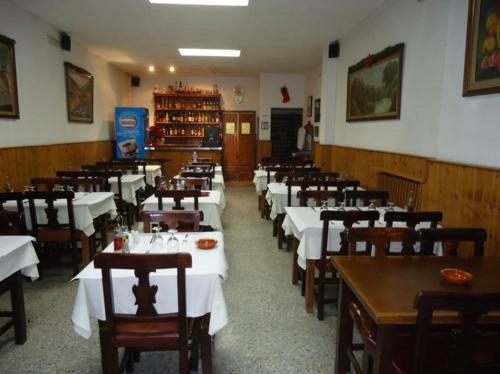 安道尔城因达罗餐厅旅馆的用餐室配有桌椅和白色桌子