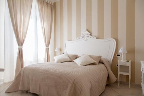 斯培西亚拉迈松德斯安格斯公寓的卧室配有白色床和条纹墙