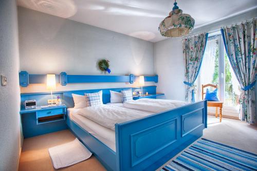 巴特莱辛哈尔Ferienwohnung Christiane - Steilhofweg / Feuerwehrheimstrasse的蓝色卧室,配有一张大床和蓝色床头板
