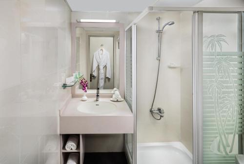 迪拜萨沃伊公园公寓酒店的白色的浴室设有水槽和淋浴。