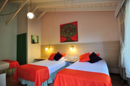 卡诺阿卡诺瓦酒店的一间设有两张红色和白色床单的房间