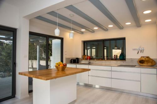 海法Eshkol Housing Haifa - Wallenberg Suites Complex的厨房配有白色橱柜和木制台面