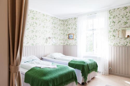 Lemland阿玛利亚酒店的绿毯间内的两张床