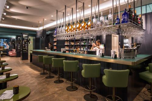 马德里敏特文奇酒店的酒吧餐厅,设有绿色酒吧凳子