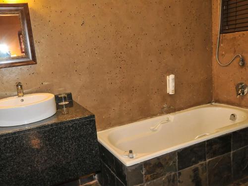 Sibasa2Ten Hotel的浴室配有盥洗盆和浴缸。