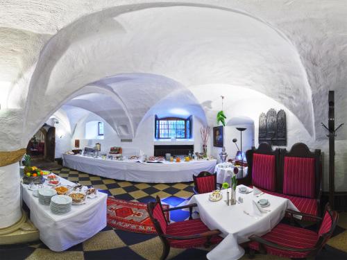 明斯特施洛斯维尔金赫吉酒店的一间位于隧道内的餐厅,配有白色的桌椅