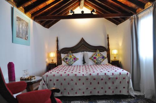 舍夫沙万里亚德彻利法旅馆的一间卧室配有一张大床和木制床头板