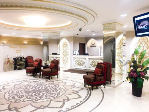 喀山比利亚尔宫酒店的一间设有椅子和桌子的等候室以及一台电视