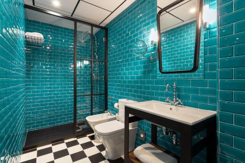 马拉加瓦莱里娅室友酒店的蓝色瓷砖浴室设有水槽和卫生间