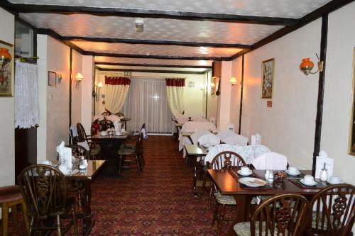 依尔福克兰布鲁克酒店的用餐室配有桌椅和白色桌布