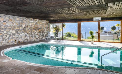 洛迦诺Collina d'Oro Orselina Locarno的一座大型游泳池,位于一座带大窗户的建筑内