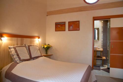 Saint-Julien-les-VillasLe Petit Saint-Julien的一间卧室,配有一张床和花瓶