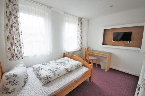 巴特苏德罗德Spa公园酒店的一间卧室配有一张床、一张书桌和一台电视