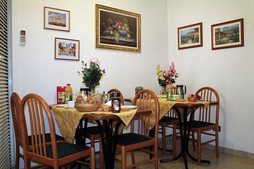 罗马Emanuela B&B的用餐室配有桌椅和鲜花