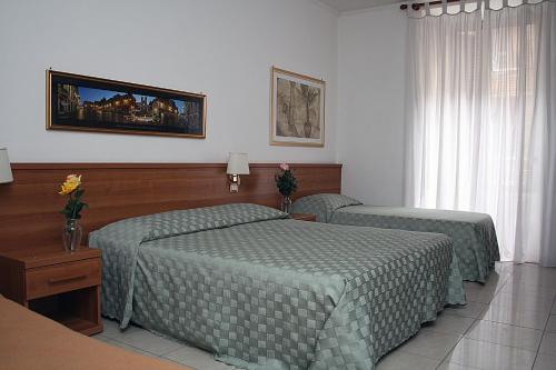 罗马Emanuela Guest House的一间卧室配有两张带绿色棉被的床