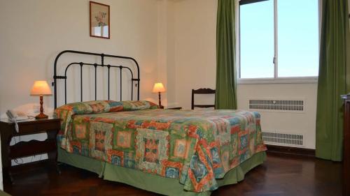 萨尔塔萨尔塔酒店的一间卧室配有一张床、一张桌子和一个窗户。