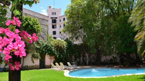 萨尔塔萨尔塔酒店的一个带游泳池和椅子的庭院和一座建筑