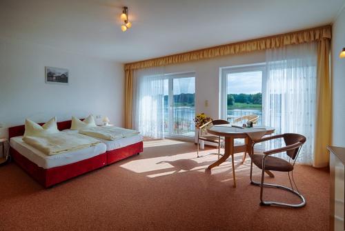 德绍布拉姆巴赫埃布特拉森酒店的一间卧室配有一张床铺和一张桌子,还有一间用餐室