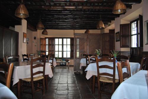 皮特尔圣罗克乡村酒店的餐厅设有白色的桌椅和窗户。