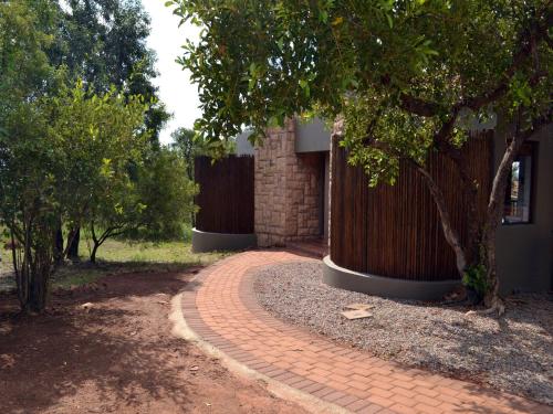 贝拉贝拉Elements Private Golf Reserve的砖砌的走道,旁边是树木的建筑
