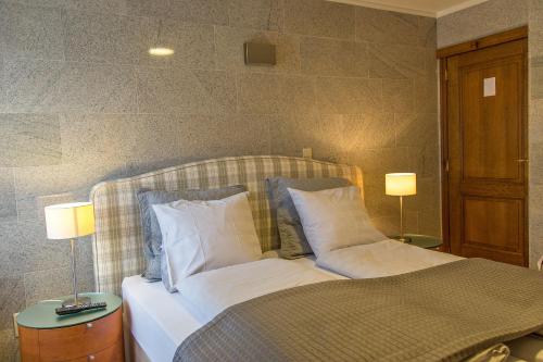 马塞克威尔盖恩霍夫酒店的一间卧室配有一张带枕头的床和两盏灯。