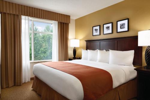 哥伦比亚卡尔森乡村酒店和套房，哈比森哥伦比亚，SC的一张位于酒店客房的大床,设有窗户