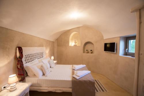 阿克罗蒂里Love Nest with hot tub, hammam & outdoor cinema的卧室配有白色的床和窗户。