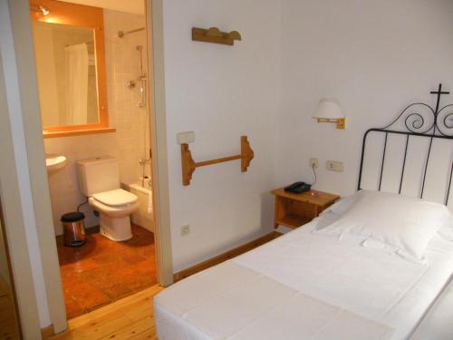 佩雷拉达德拉弗昂特佩尔拉达酒店的一间卧室配有一张床,浴室设有卫生间