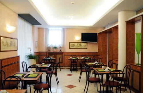 帕尔马布通酒店的餐厅设有桌椅和平面电视。