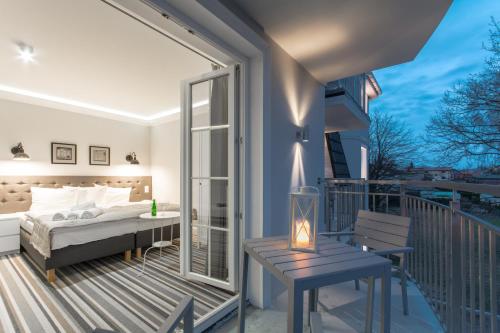 米兹多洛杰Villa Astra Baltica的一间卧室设有1张床铺和1张桌子的阳台