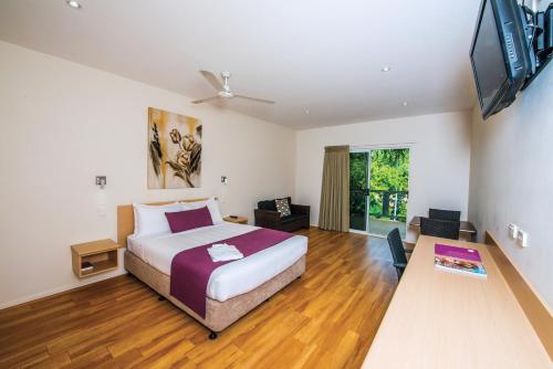达尔文达尔文热带俱乐部度假酒店的一间卧室配有一张床和一台平面电视