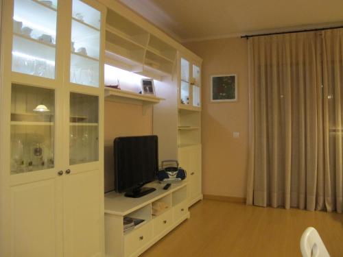 帕拉弗鲁赫尔Nice apartment in Costa Brava的一间客厅,客厅的白色橱柜上配有电视