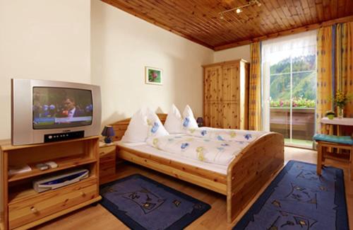 伦韦格沃德霍斯旅馆的一间带床和电视的客厅