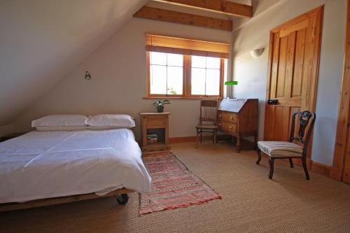 CulbokieNetherton Farm B&B的一间卧室配有一张床、一张书桌和一个窗户。