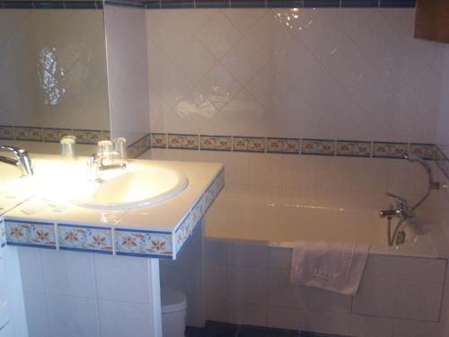 阿尔利河畔普拉兹伯纳德酒店的浴室配有盥洗盆和浴缸。