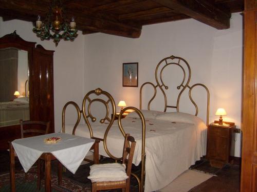 San Pellegrino al CasseroB&B Le Limentre的一间卧室配有一张带桌椅的床