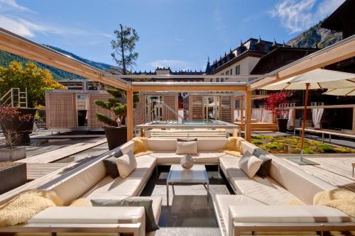 采尔马特后台精品SPA酒店的一个带沙发和游泳池的户外庭院