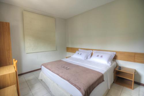 萨尔瓦多Hotel Pedra da Concha的卧室配有白色大床和白色枕头