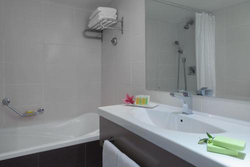 埃拉特莱昂纳多埃拉特全包酒店 的白色的浴室设有水槽和镜子