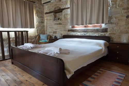 皮特斯迪亚O Ilios House的一间卧室配有一张带白色床单的大床