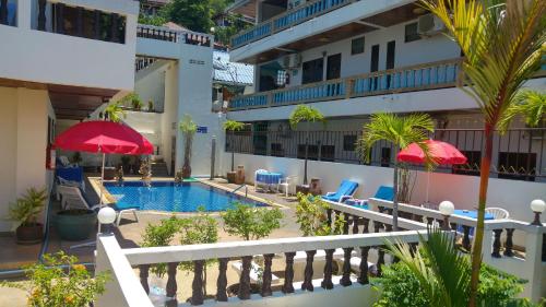 芭东海滩蓝天公寓式酒店的一个带游泳池、椅子和遮阳伞的酒店