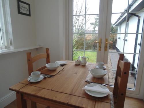 斯托诺韦Woodside Guest House的木桌,上面放着碗和盘子