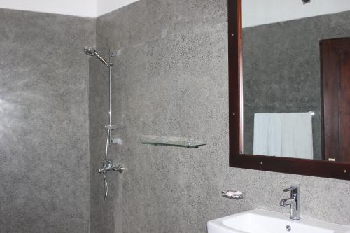 坦加拉隐居山林小屋的带淋浴、水槽和镜子的浴室