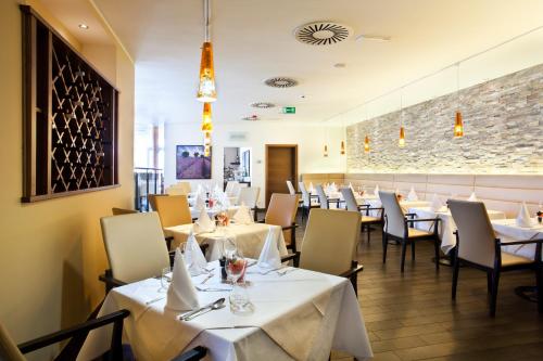 科济纳Casino & Hotel ADMIRAL Kozina的一间设有白色桌椅的用餐室