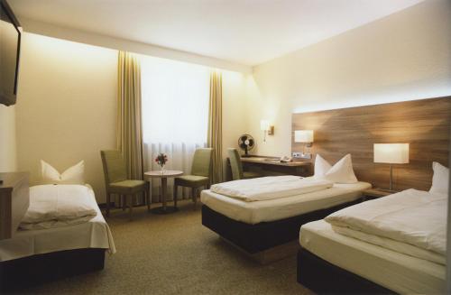 慕尼黑杰德曼旅店的酒店客房配有两张床和一张书桌