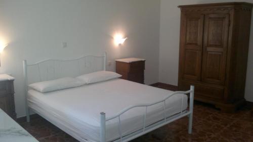 莱乌卡Appartamento Barbara的卧室配有白色的床和木制橱柜。