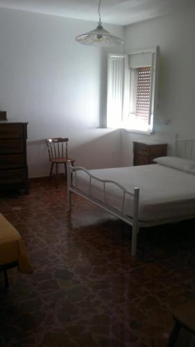 莱乌卡Appartamento Barbara的一间卧室设有一张床、一个窗口和一把椅子