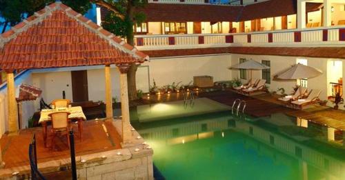 Kānādukāttān池达巴瑞维拉斯度假村 - 豪华遗产度假胜地的一个带椅子的大型游泳池