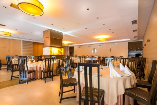 克卢日-纳波卡纳波卡大酒店的一间带桌椅和壁炉的用餐室