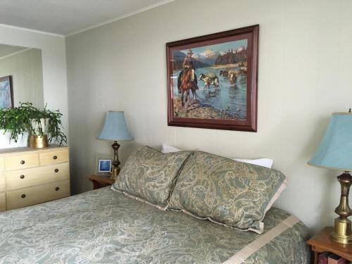 SagleSleep's Cabins的卧室配有一张床,墙上挂有绘画作品